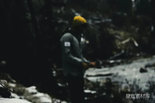 一个男子站在覆有白雪的斜坡顶端