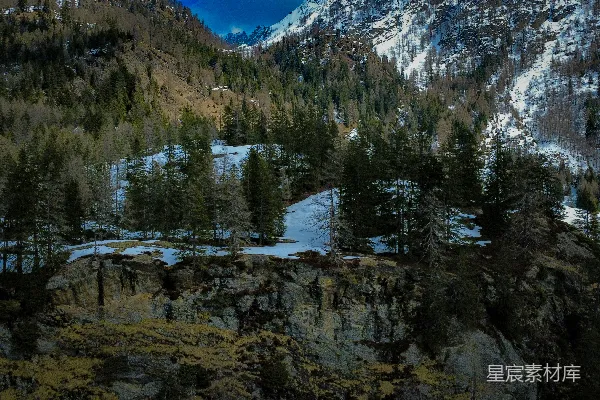 高清摄影 山峦上有树木、积雪和晴朗的天空。