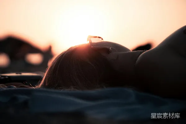 海滩上一个女子躺在沙滩上靠近海边