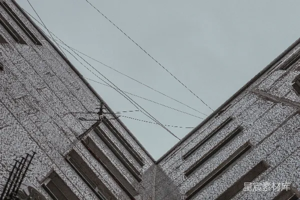 仰望一片灰暗的建筑和天空。