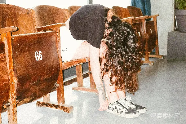 黑色上衣的女人坐在棕色的沙发布艺椅上