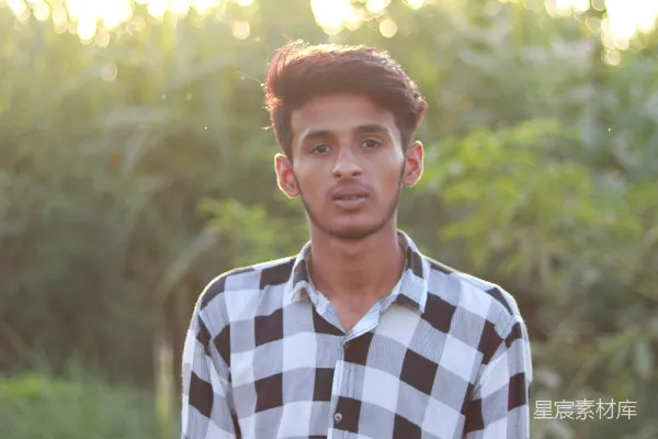 一个年轻人站在一片森林前