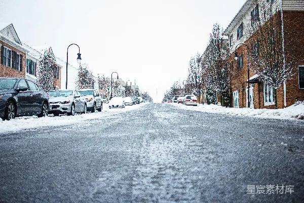 雪覆盖的街道，车停在一边。