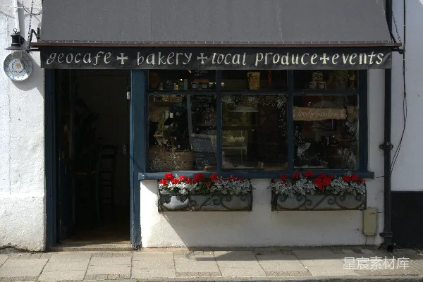 一家充满温馨的生态咖啡馆和 Bakery 店面，周围摆满了鲜艳的花箱。