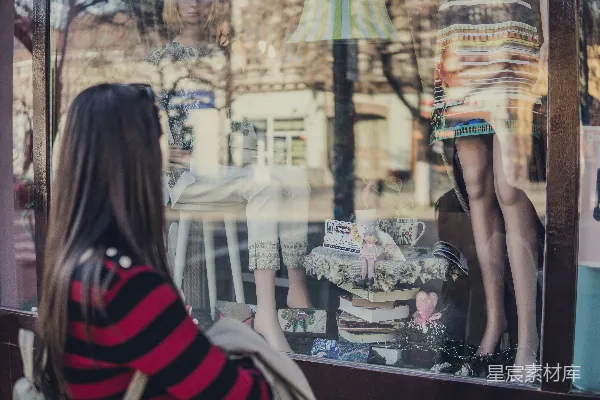 妇女站在商店附近看着模特儿。