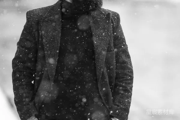 一个穿外套戴着墨镜的人站在雪地里