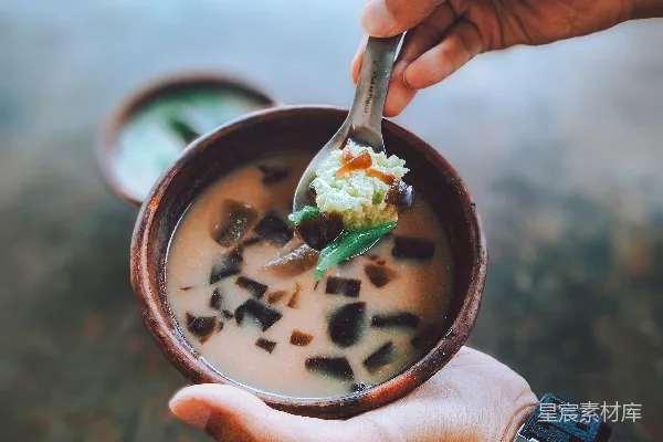 手持一碗食物的人，手里拿着勺子。