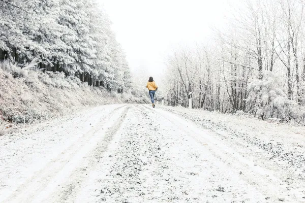 黑色夹克和蓝色牛仔裤的人在覆盖着白雪的道路 daytime行走