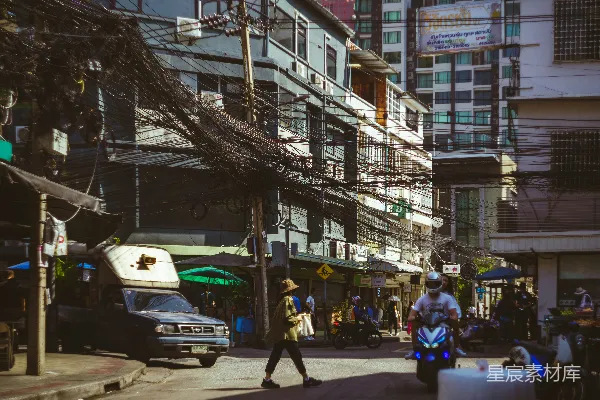一个男人走在一旁有高大建筑的街道上