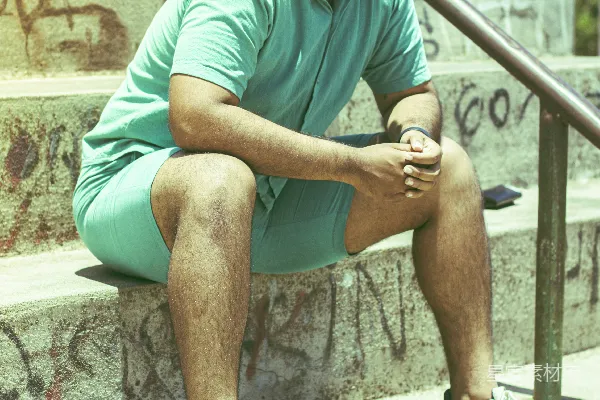 一个男人坐在一排台阶上戴着太阳镜