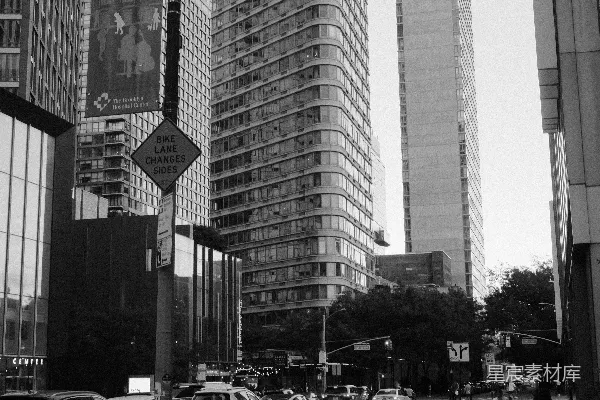 现代城市街道上高大的建筑物和停着的汽车。