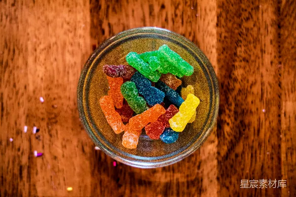 木桌上方放着一个装满胶糖棒的玻璃碗。
