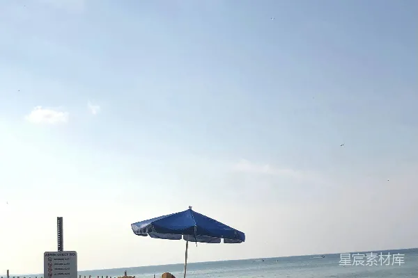 一个有蓝色阳伞和椅子的海滩