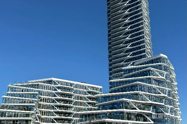 现代建筑在蓝天下拥有独特的波浪形外墙。