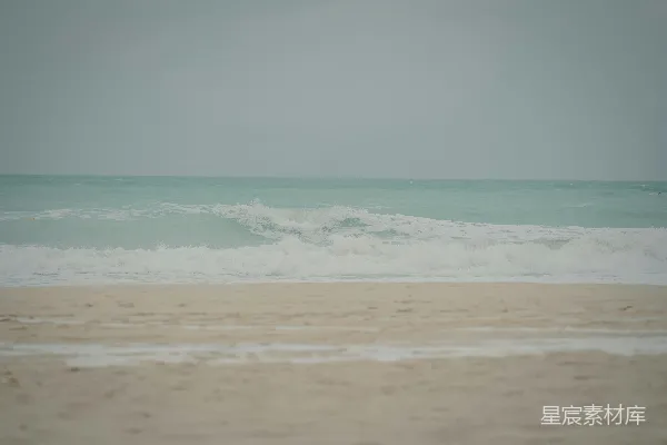 一幅模糊的海滩照片，海浪涌来。