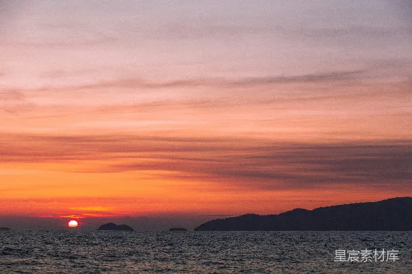 夕阳映照在一片水面上，背景是连绵的山峦。
