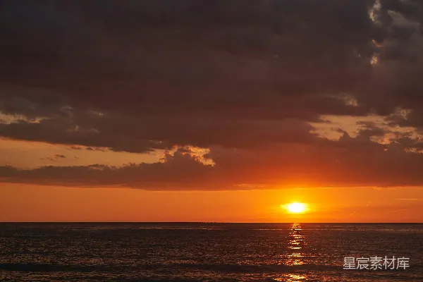一天的夕阳映照在有云的海面上