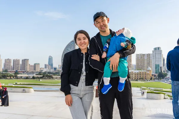 家庭在城市天际线前摆姿势照相，小孩在中间。