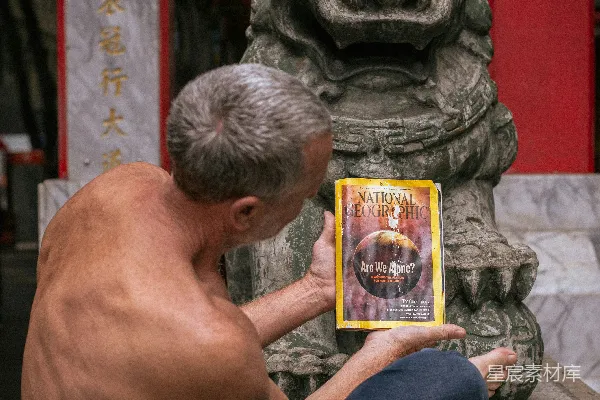 地上坐着一个人手中拿着一本书