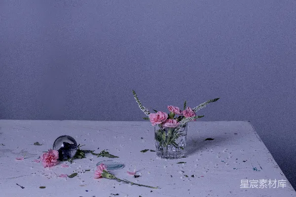 桌上有只装有粉红色花朵的玻璃花瓶。