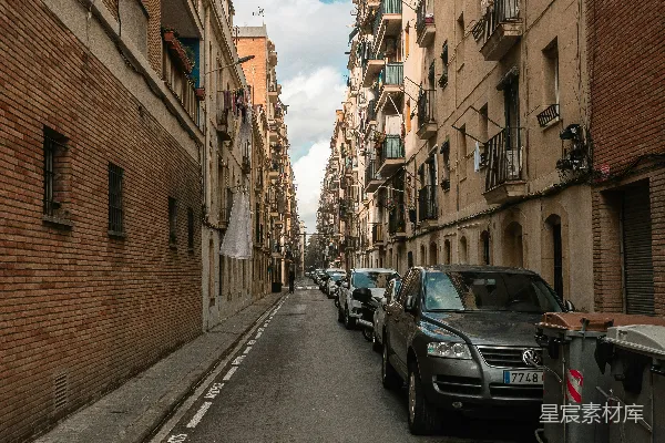 一条停满汽车的街道旁边是高大的建筑物