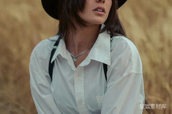 一顶帽子的女人坐在田里