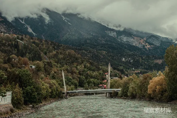 一座桥横跨一条河，山峰在背景中。