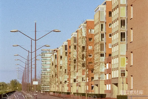 一条紧挨着绿油油田野的高大建筑夹道的道路