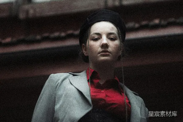 一个戴着红领结的女人站在一栋建筑物前。