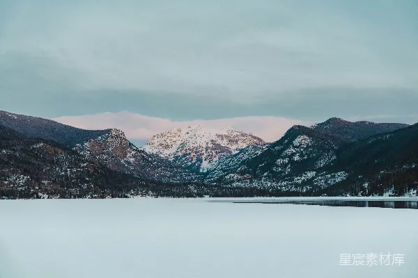 覆盖着白雪的山脉，在前景中有一片湖泊。