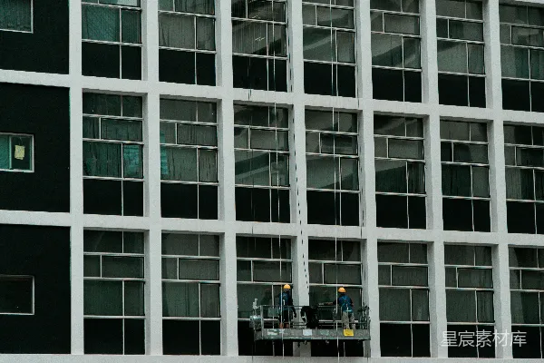 几个男子站在一栋高建筑前的脚手架上