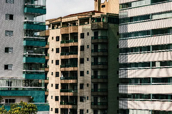 高耸的带有阳台和树木的公寓建筑。