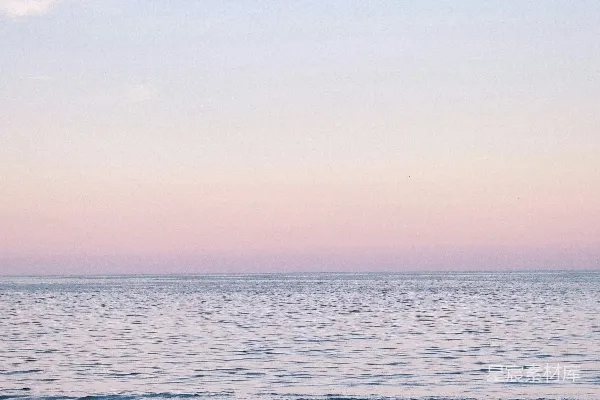 海滩上一个人拿着冲浪板行走