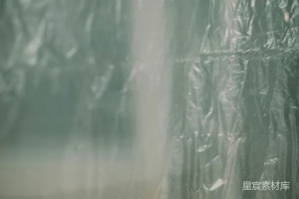 高清摄影 一个人站在一堵覆盖着塑料的墙前。