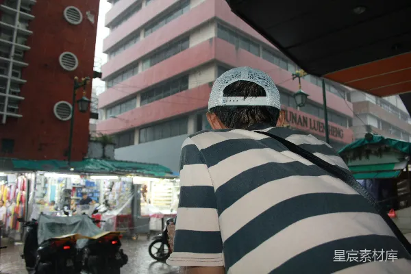 一件格子衬衫的男人站在一栋建筑的前面
