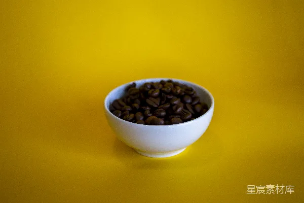 黄色背景上的一碗咖啡豆