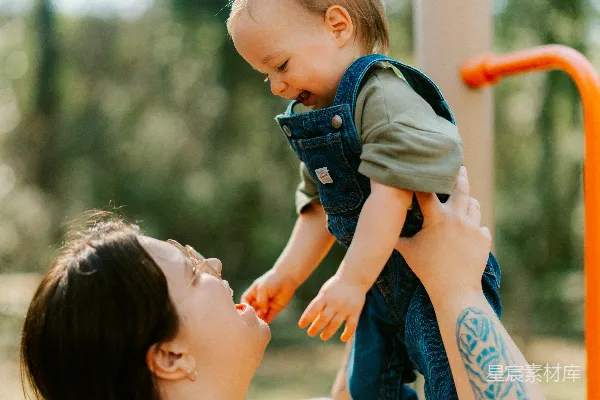 母亲在游乐场抱着她的婴儿。