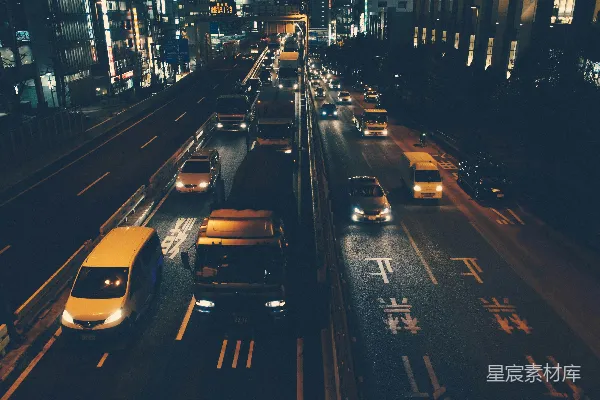 夜空下白建筑附近道路旁的车辆的 aerial 照片