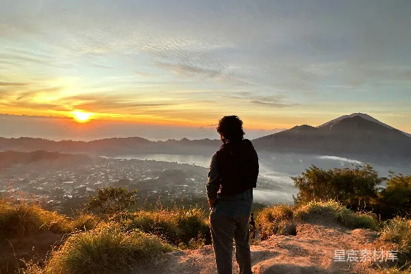 山顶上站立着一个人在夕阳西下之时