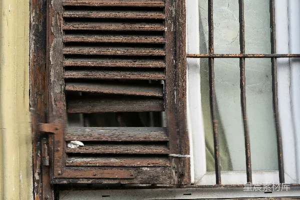 一栋建筑上的一扇破旧木百叶窗