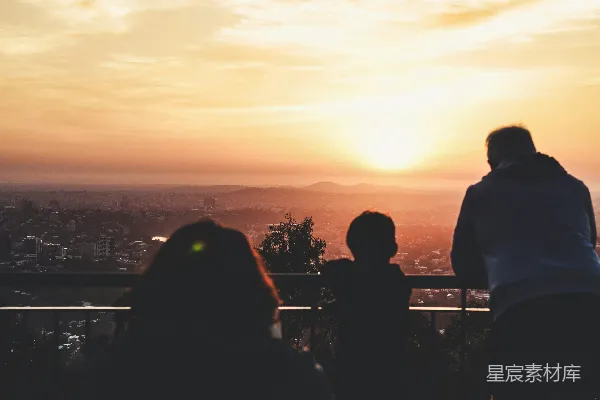 傍晚时分孩童与男子并立在铁轨旁的轮廓图象