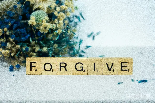 一块写有“for give”的木头块旁边摆放着一束花。