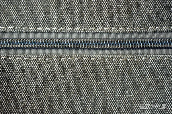 高清摄影 一扇灰色拉链特写，织物上带有白色缝线。