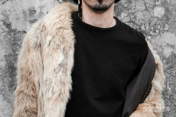 一个戴着帽子和太阳镜的男人站在一辆出租车的前面。