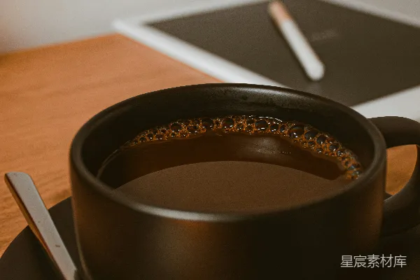 黑色陶瓷咖啡杯放在棕色木制桌子上