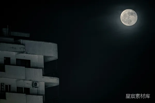 一座建筑矗立在夜空中的满月旁。