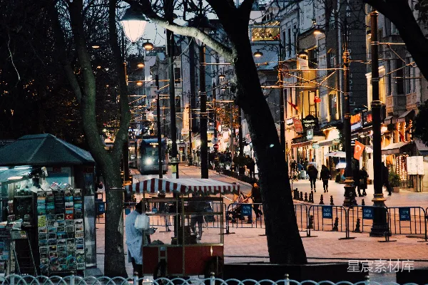 夜幕下人们走在靠近建筑物的 sidewalks 上