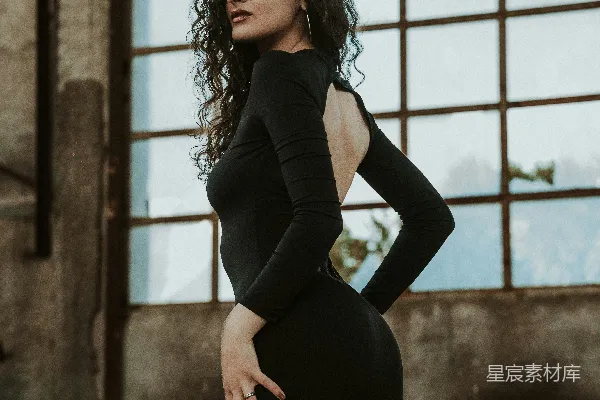 一个穿黑色连衣裙的女人正在拍照。