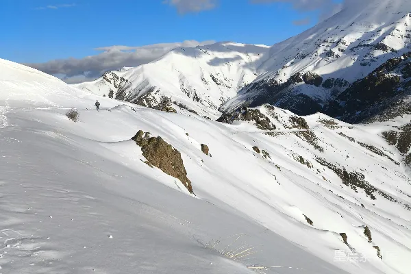 一个男人骑滑雪板滑下覆盖着白雪的斜坡