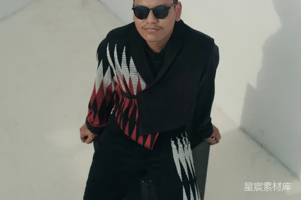 一个穿黑色夹克和戴墨镜的男人正在拿着一个行李箱